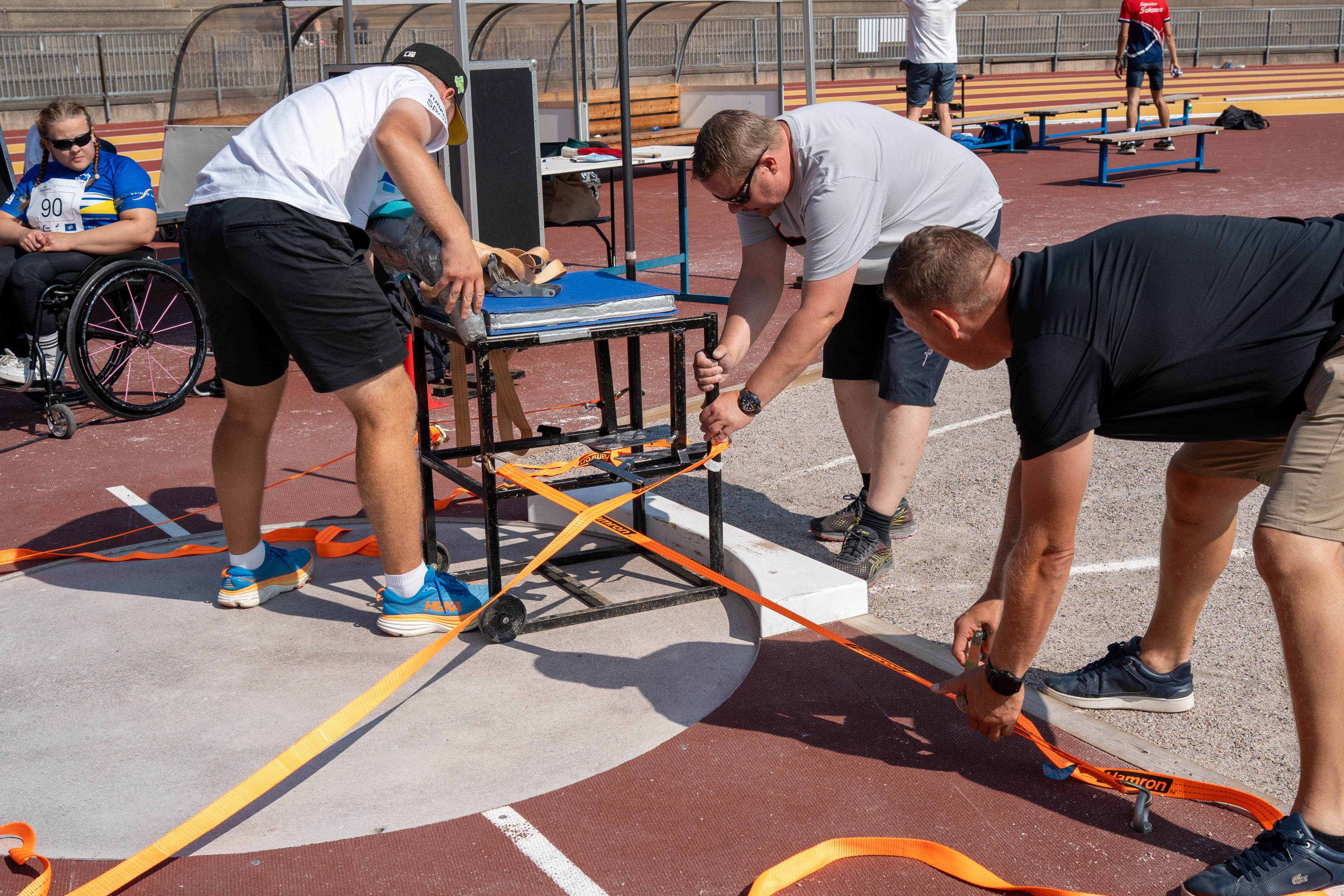 Kuvassa kiinnitetään heittotuolia heittoympyrään liinoilla.